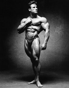 a man posing for a black and white photo with his arms crossed in front of him