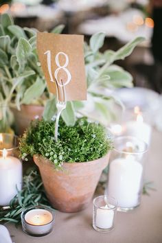 the table is set with candles and greenery