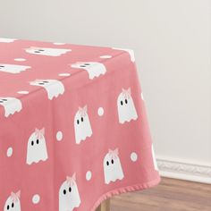 a pink table cloth with ghost faces on it