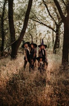 three witches standing in the middle of a forest