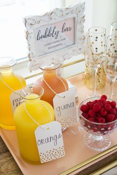 a tray topped with drinks and fruit on top of a table