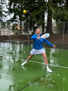 a man in blue shirt and white shorts playing tennis on green court with yellow ball