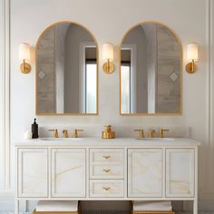 a bathroom with two sinks and mirrors on the wall next to each other in gold trimmings