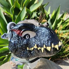 a toy dinosaur head sitting on top of a wooden table