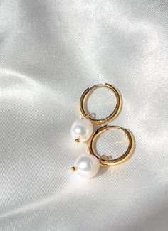 The Elora earrings are small hoop earrings adorned with a fresh water pearl. Simple and elegant, making them the perfect pair for a casual day out or a dressed up look. - Composed of - Stainless steel 18k gold plating Fresh water pearls tarnish free & hypoallergenic Classic Gold Pearl Huggie Earrings, Gift 14k Gold Hoop Earrings With Pearl Chain, Everyday Pearl Charm Hoop Earrings, Everyday Pearl Hoop Earrings With Pearl Pendant, Everyday Hoop Earrings With Pearl Pendant, Dainty Pearl Chain Hoop Earrings As Gift, White Gold Plated Hoop Pearl Earrings, Everyday Pearl Chain Hoop Earrings, Small Pearl Hoop Earrings For Everyday