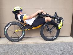 a man sitting on top of a bike next to a garage door wearing a helmet