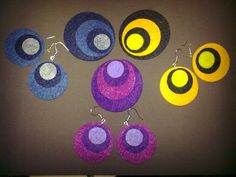 several different colored earrings and earring sets on a table with a brown surface in the background