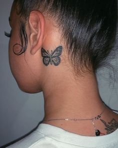 a woman's neck with a butterfly tattoo on the back of her left ear