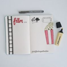 an open notebook with film and popcorn on it