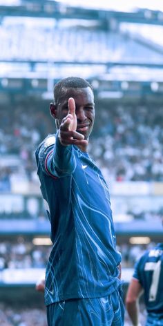 a man giving the thumbs up sign at a football game