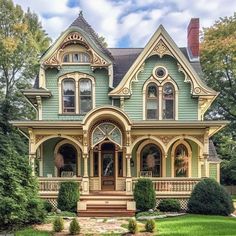 an old victorian style house with green paint and wood trimmings on the front porch