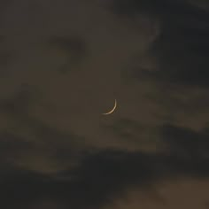 the moon is seen through some dark clouds