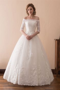 a woman in a white wedding dress posing for the camera with her hands on her hips