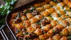 a casserole dish with meat and cheese on top, garnished with parsley