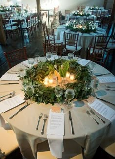 the table is set up with place settings for dinner and reception guests to sit at