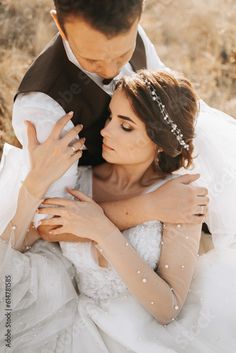 a bride and groom embracing each other in the desert