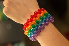 a woman's arm with a bracelet made out of multicolored plastic beads