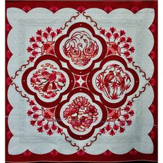 a red and white quilt with flowers on it