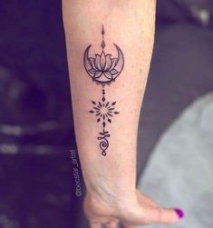 a woman's foot with a tattoo on it that has a lotus and stars