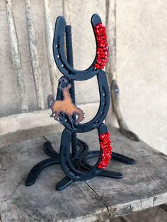 a horse shoe shaped sculpture on top of a wooden table next to a white wall