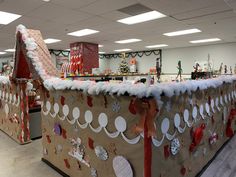 a large gingerbread house with decorations on the front and sides in an office setting