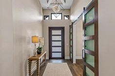 an entry way with a light fixture and wood flooring, along with a white rug