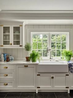 a kitchen with white cabinets and marble counter tops, along with an open window to the outside