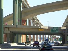 cars are driving under an overpass on the highway