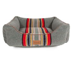 a dog bed that is grey with multicolored stripes