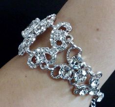 "A Victorian wedding style bridal bracelet made of clear swarovski crystals with a big oval cubic zirconia set onto detailed curl swirl frames in silver rhodium tarnish resistant finish. Bracelet crystal is 1 1/8\" (3cm) wide. Main focal crystal centerpiece is fixed at 1 1/2\" long while the rest are flexible joints. View matching pieces or similar designs at https://etsy.me/2sh8gPa View other Victorian inspired accessories https://etsy.me/2uAseFc View all bracelets at https://etsy.me/S9RHlf" Glamorous Sparkling Bracelets For Wedding, Glamorous Silver Bracelets For Wedding, Glamorous Sparkling Bracelet For Wedding, Silver Crystal Embellished Bracelet Gift, Silver Crystal Embellished Bracelet For Gift, Dazzling Rhinestone Wedding Bracelets, Silver Rhinestone Bracelets For Wedding, Glamorous Wedding Bracelets With Bling, Silver Crystal Embellished Wedding Bracelet