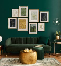 a living room with green walls and pictures on the wall above the couch is a gold coffee table