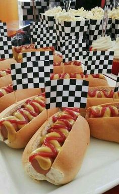 hotdogs with ketchup and mustard are on display at a race themed birthday party