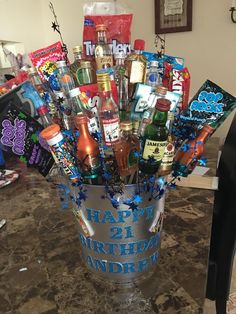 a bucket filled with lots of different types of drinks and snacks on top of a table