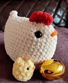 there is a crocheted chicken next to a golden egg on the couch with it's head down