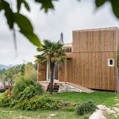 a wooden house sitting on top of a lush green field