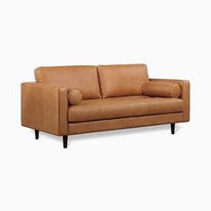 a tan leather couch with two pillows on it's arms and backrests