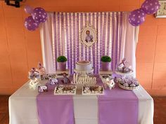 a purple and white dessert table with balloons