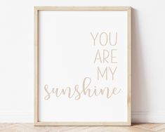 a white framed poster with the words you are my sunshine on it in blue ink