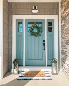 a blue front door with a welcome mat on it