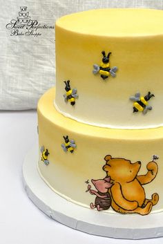 a three tiered cake decorated with winnie the pooh and honeybees on it