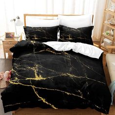 a black and gold marbled comforter set on top of a wooden bed with white pillows