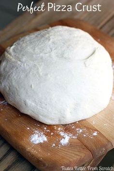 a ball of bread sitting on top of a wooden cutting board