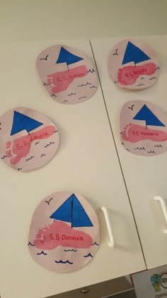 four pieces of paper that have been cut out to look like boats on the water