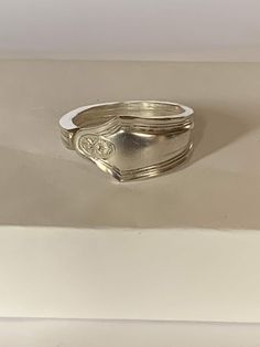 a silver ring sitting on top of a white box