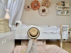 a child's room with a white bed, pink rug and two swans on the wall