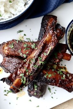 ribs and rice on a plate with sauce