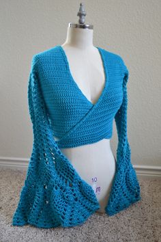 a crocheted blue shawl on a mannequin's torso is shown