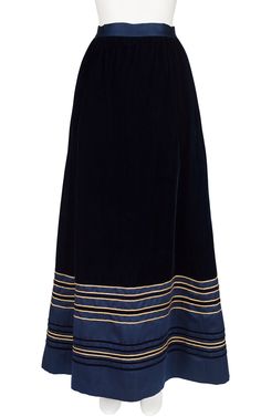 "This navy floor-length maxi skirt was designed in the early 1970s by Rizkallah for Malcolm Starr. It's made from lined navy blue velvet with a gold metallic and satin trim. It has a pocket on each side and does up the back with a hidden zipper and two hook-and-eyes on the waistband. It's in excellent condition, has been professionally dry-cleaned and is ready to wear.  Measurements: Waist - 24\" Hips - 44\" Length - 43\" IMPORTANT NOTE FOR CANADIAN SHOPPERS: There is a 15% shipping fee that is Evening Skirts, Navy Blue Velvet, Velvet Maxi, Blue Velvet, Hidden Zipper, Vintage Gold, Floor Length, Maxi Skirt, 1970s