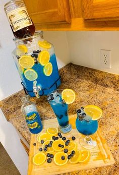 blue and yellow drinks sitting on top of a wooden cutting board