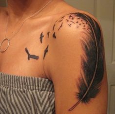 a woman with a tattoo on her shoulder that has birds flying in the sky above it